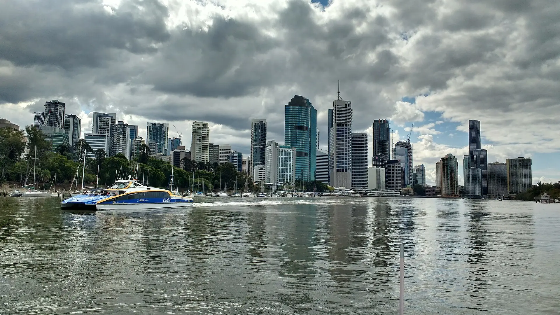 Brisbane CBD office towers rising above the Brisbane River with a ferry crossing