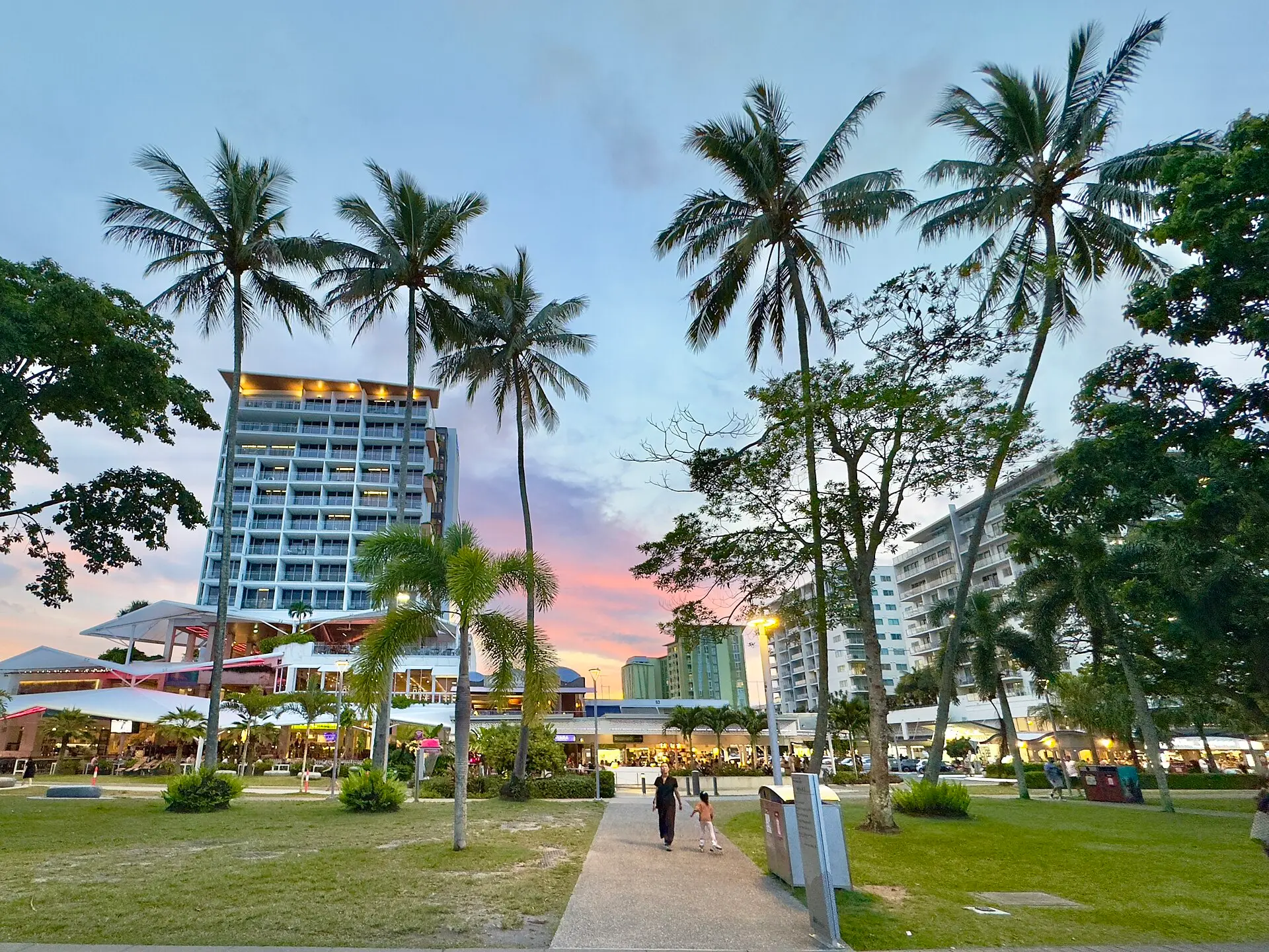 Cairns Esplanade lined with palm trees and hotels at dusk