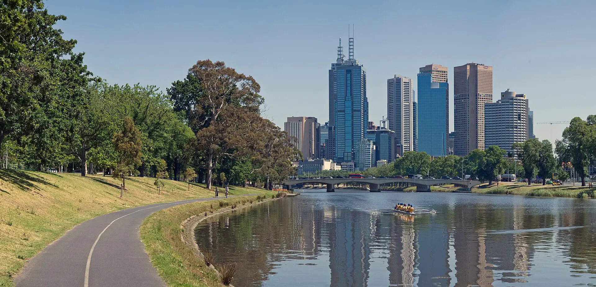 Melbourne CBD towers beside the Yarra River with a riverside bike path in the foreground